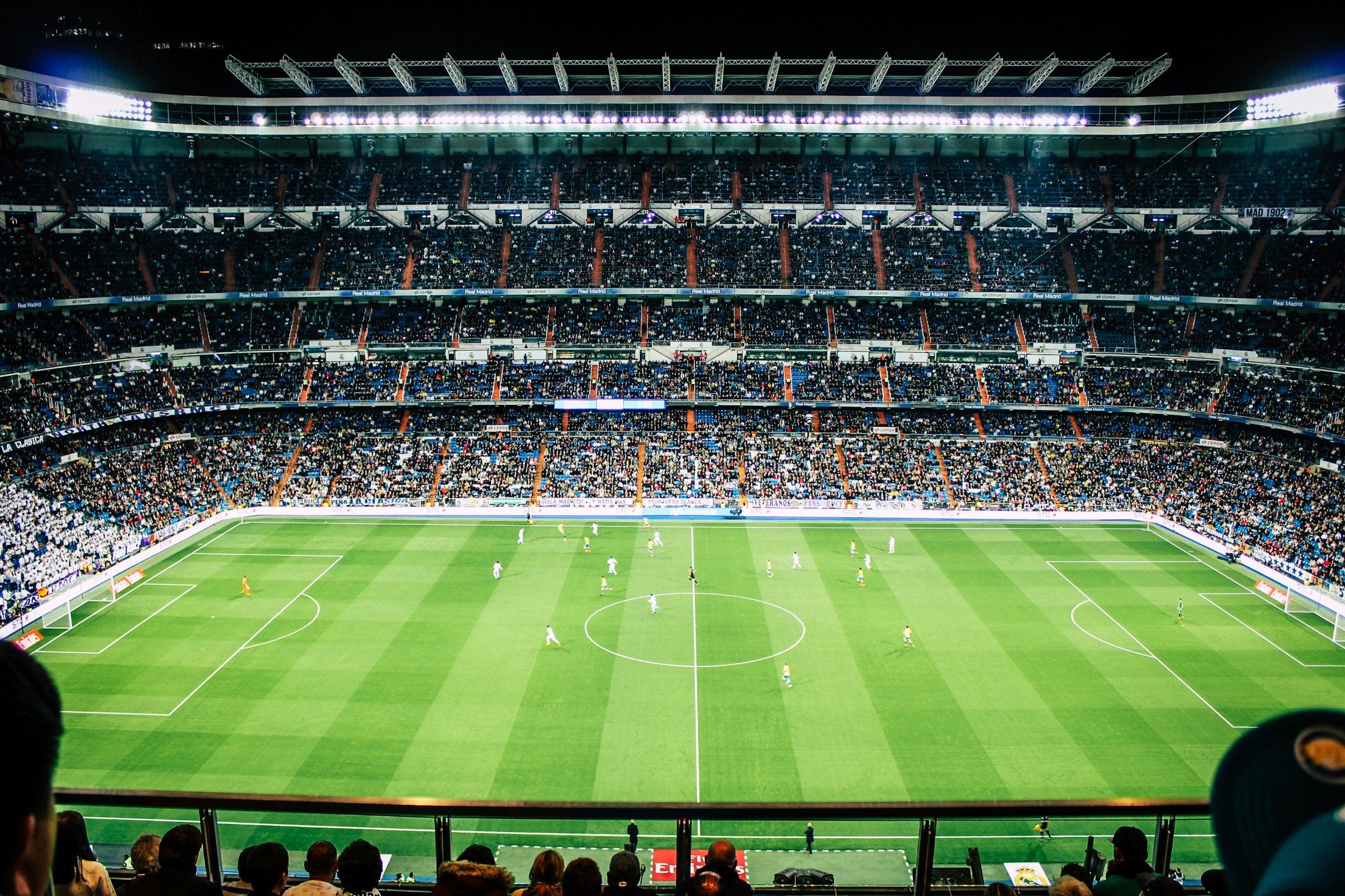 Packed soccer stadium under floodlights at night