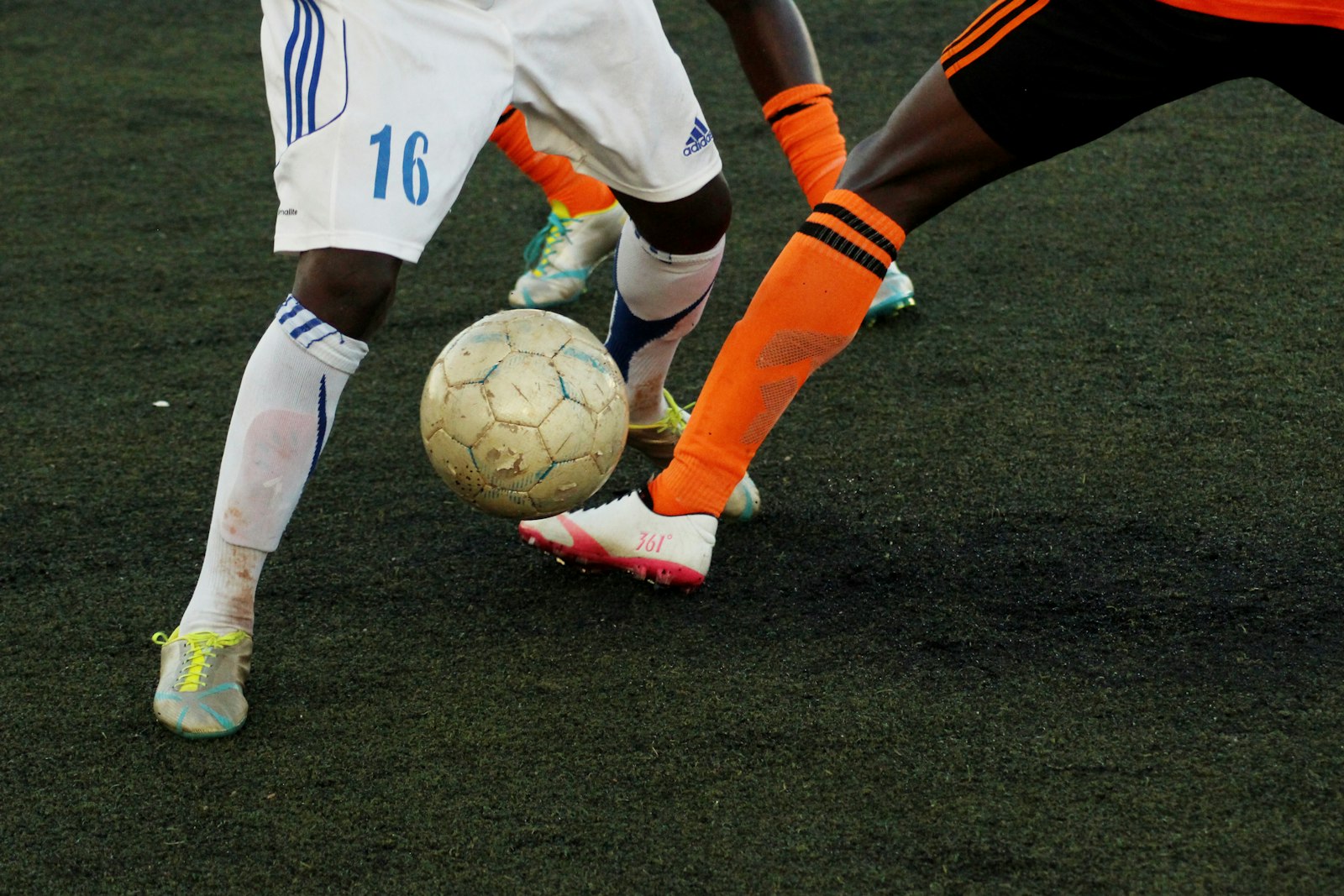 Soccer player volleying the ball on a green pitch