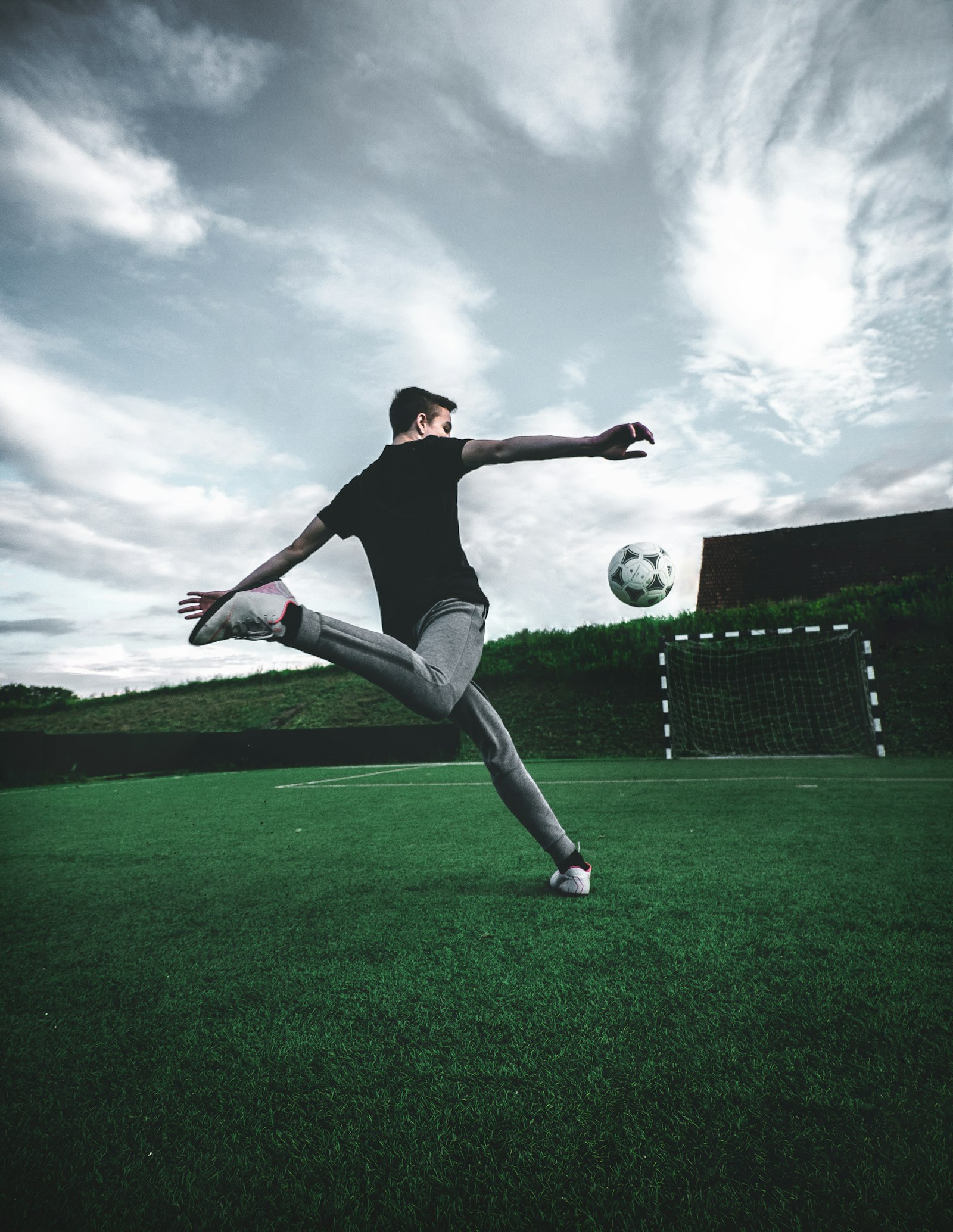 Soccer player mid-kick sending the ball toward goal